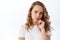 Thoughtful woman looks suspicious aside, frowning and thinking, having doubt, standing over white background