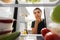 Thoughtful woman at open fridge at home kitchen