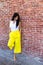 Thoughtful woman in trendy bright yellow pants