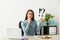 Thoughtful young woman holding sheet of paper with exclamation and interrogation marks at workplace