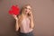 Thoughtful young woman with piece of puzzle on color background