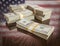 Thousands of Dollars with Reflection of American Flag on Table