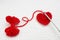 Thread loops, handmade crochet heart and a small red yarn ball on the white crochet background. Romantic Christmas or Valentines D