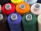 Threads of different colors on spools, standing vertically,oblique top view, close up