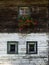 Three 3 windows, historical farmhouse in the alps with red flo