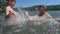 Three active boys making splashes in water.