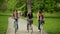 Three Active Young Women are Riding Together in the City Park. Smiling Brunettes with Bicycles Outdoors.