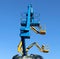 Three aerial working platforms of cherry picker against blue sky.