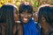 Three african american friends kissing sitting on the bench at the park