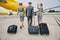 Three aircrew members in uniforms walking towards the landed airliner