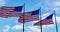 Three American Flags fluttering against light blue sky