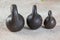 Three antique iron weights for scales on concrete background