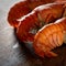 Three appetizing boiled lobster on a dark wooden background