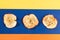 Three apple chips are lying  on blue band on yellow-orange background