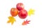 Three apples and several autumn leaves on a light background