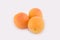 Three apricots lie side by side isolated
