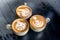 Three aroma cappuccino coffee cups with pictures