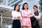 Three Asian business girls are acting as confident with their work and smiling to express of happy during day time outside the