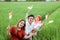 Three Asian friendly smile posing hold a small flag sitting in the middle of rice fields