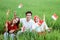 Three Asian friendly smile posing hold a small flag sitting in the middle of rice fields