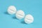Three aspirin tablets on a blue background