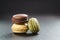 Three assorted macarons on slate board