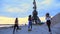 Three athletic women in a tracksuits are jogging along the sand pier of the cargo port, in the twilight of the morning