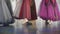 Three attractive ballerinas in colourful dresses dancing on pointe shoes in spacious studio