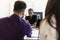 Three attractive businesspeople sitting in workplace, Young african woman handshake with new members of team in office