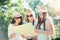 Three attractive girls looking for directions on a map at summer holidays