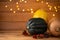 Three autumn`s pumpkins isolated on wooden background with yellow lights. Colored pumpkins. Autumn`s decoration. Thanksgiving