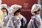 Three baby majorettes wrapped up against rain at Carnival parade