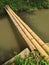 three bamboo sticks used as bridges across irrigation