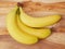 Three bananas on a wooden table,