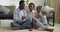 Three barefoot people couple with baby afro american family mother father and cute little girl daughter sitting at home