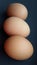 Three barn eggs over black. Fresh chicken eggs.