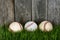 Three Baseballs on grass.