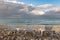 Three beach chairs at ocean front with dramatic sky clouds