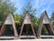 three beach huts neatly arranged with beautiful cypress trees and blue sky.