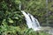 Three Bears Falls, also known as Upper Waikani Falls, cascading down a cliffside covered in lush vegetation in Haiku, Maui