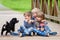 Three beautiful adorable kids, siblings, playing with cute little dog in the park