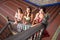 Three beautiful adult belly dancers are looking up at the camera from the bottom of the stairs. The dancers are dressed in typical