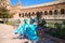 Three beautiful adult belly dancers are sitting on a park bench. They are talking and having fun with each other. Concept of