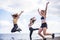 Three beautiful bodie cacuasian girls jumping on the beach doing fintess workout. outdoor leisure sport activity for group of