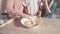 Three beautiful children help in the kitchen and mix the dough in a white plate.