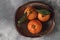 Three beautiful fresh orange tangerines on a clay plate. Organic food concept, top view