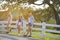Three beautiful girl standing on fence outdoor warm tone.
