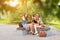 Three beautiful girlfriends eat ice cream, posing under the tree