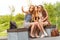 Three beautiful girlfriends make Selfie photo on a bench