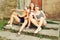 Three beautiful girls rest on the street. Beautiful happy girls in sunglasses on the urban background. Young active people. Outdoo